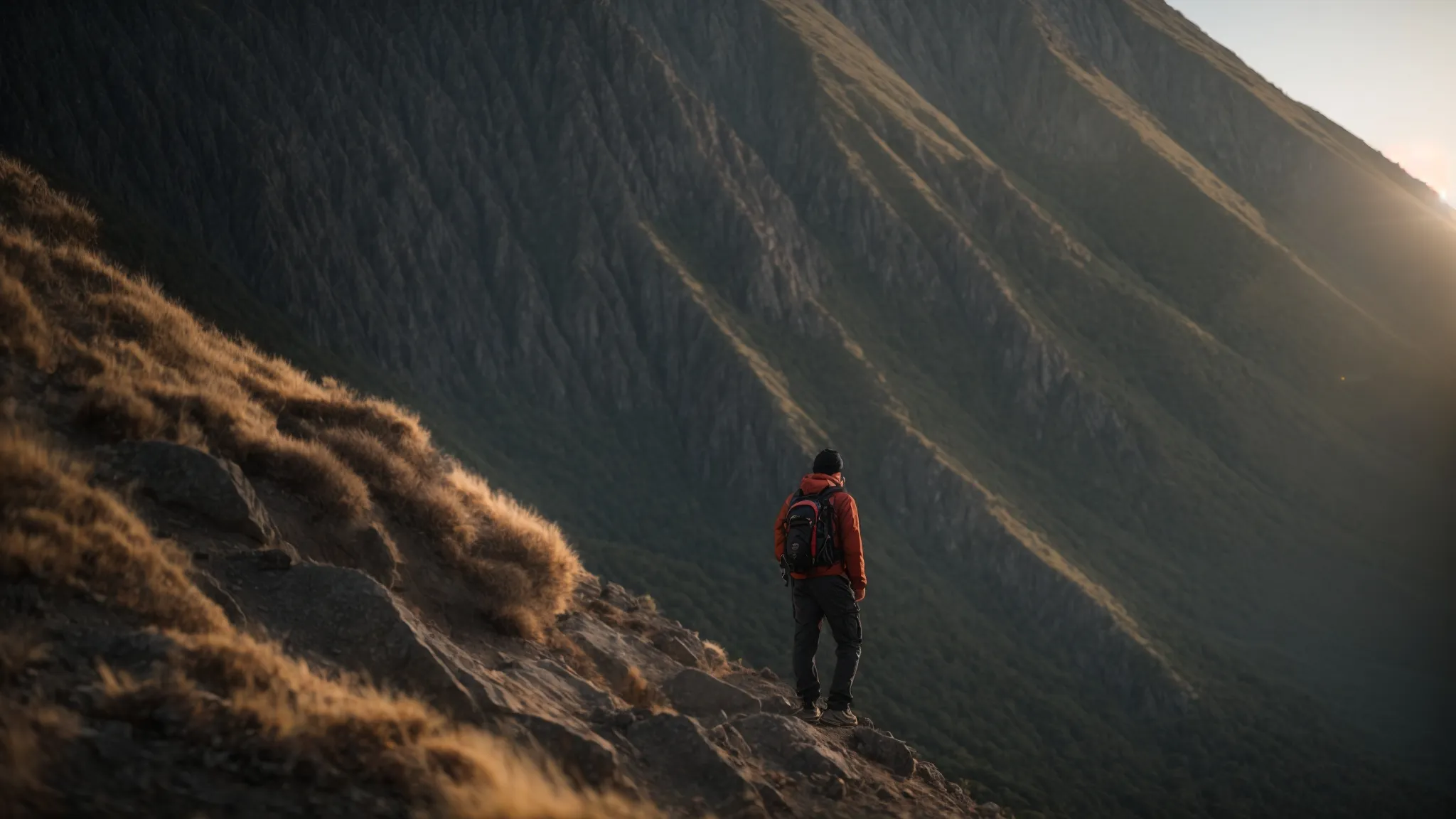 a person standing at the base of a steep mountain, looking up with determination and a positive mindset.