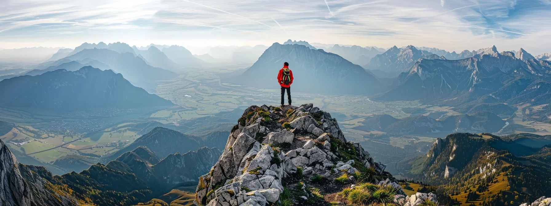 a person standing on top of a mountain, looking out at a panoramic view with a determined expression on their face.