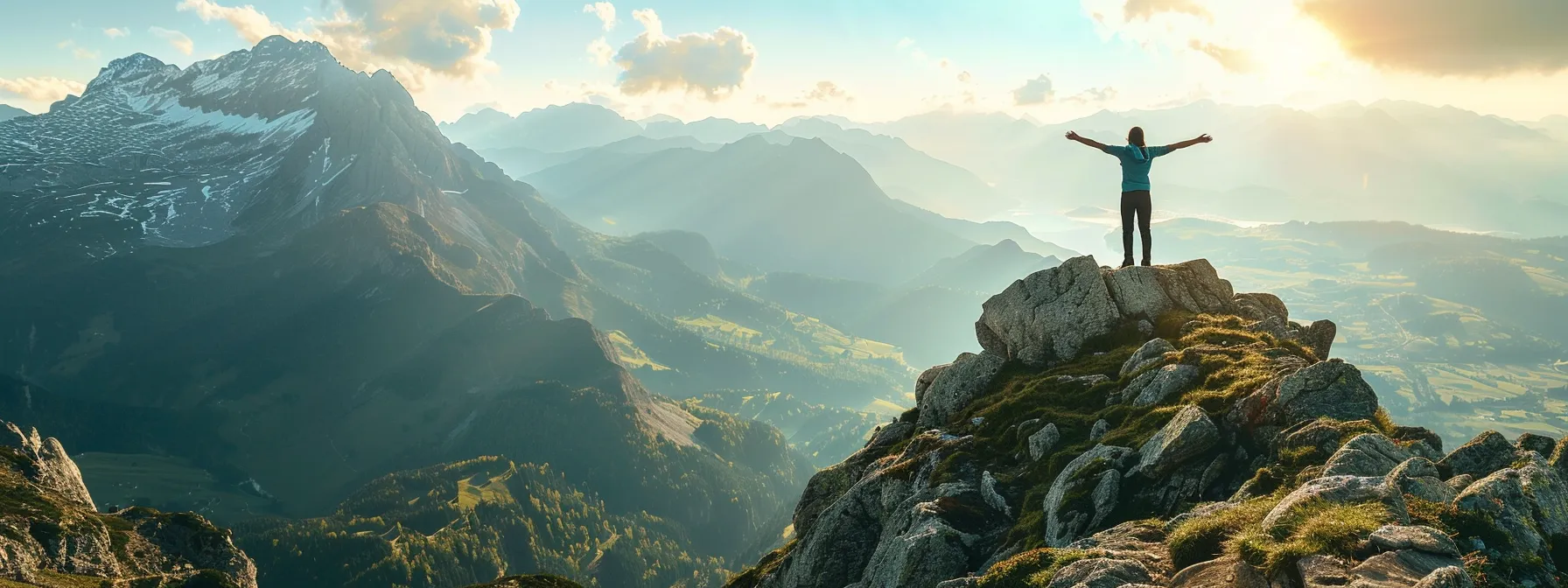 a person standing on top of a mountain, arms outstretched, taking in the breathtaking view below.