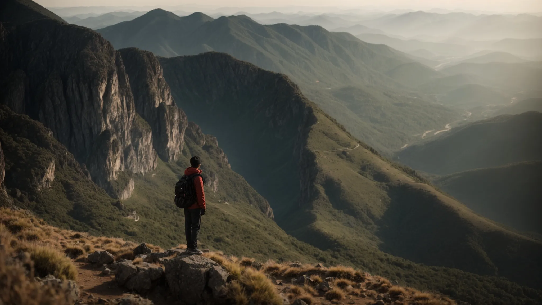 a person stands confidently at the top of a mountain, gazing out over a vast landscape.